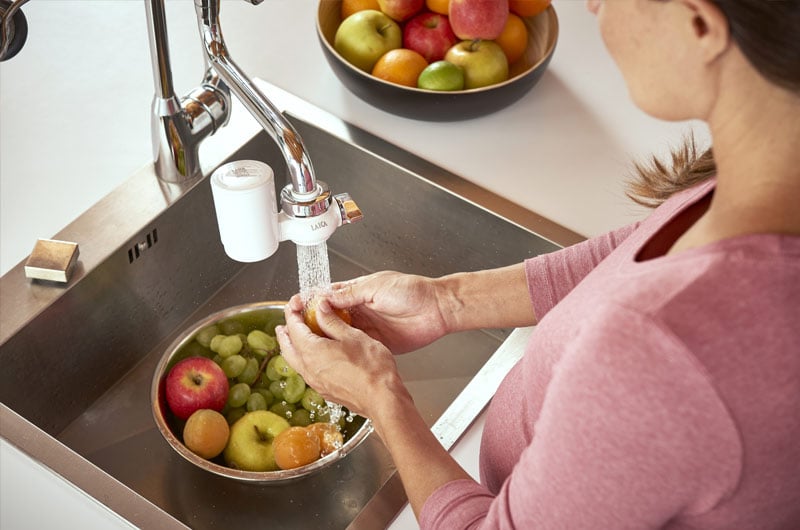 woman cleaning fruits with laica tap filter