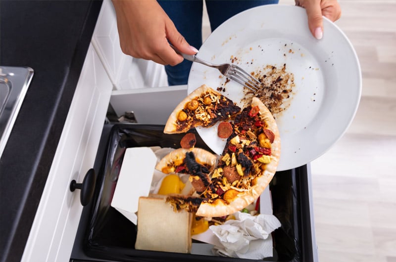  A woman throws food in the trash