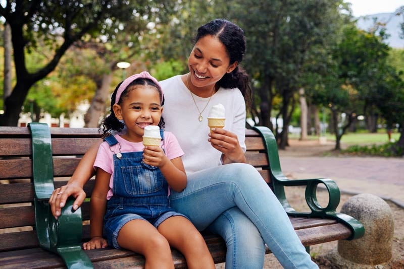 mom and daughter smiling and eating an ice cream